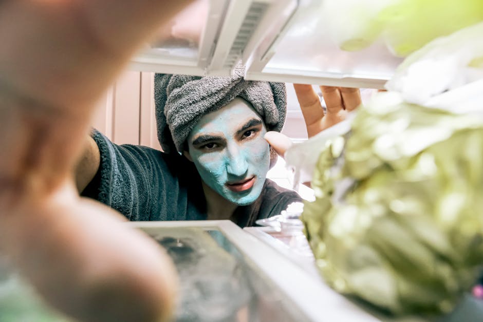 Person with a towel and face mask peering into an open fridge, surrounded by food.