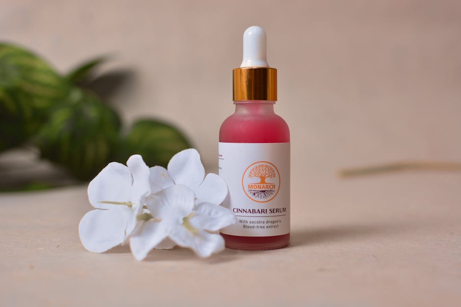 Close-up of a Cinnabari serum bottle with white flowers, ideal for skincare and beauty routines.