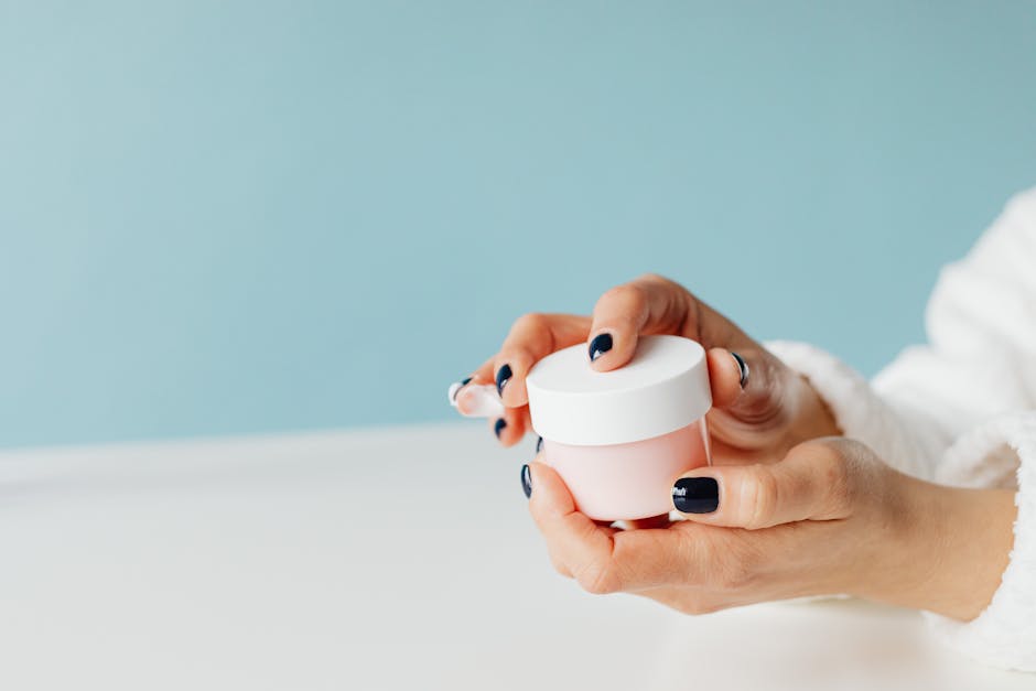 Close-up image of hands holding a skincare cream jar, focusing on beauty and self-care products.