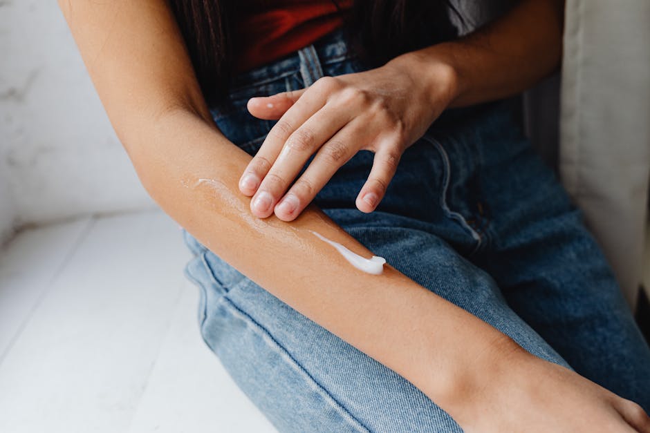 Detailed close-up of a person applying cream to their arm for skincare routine.