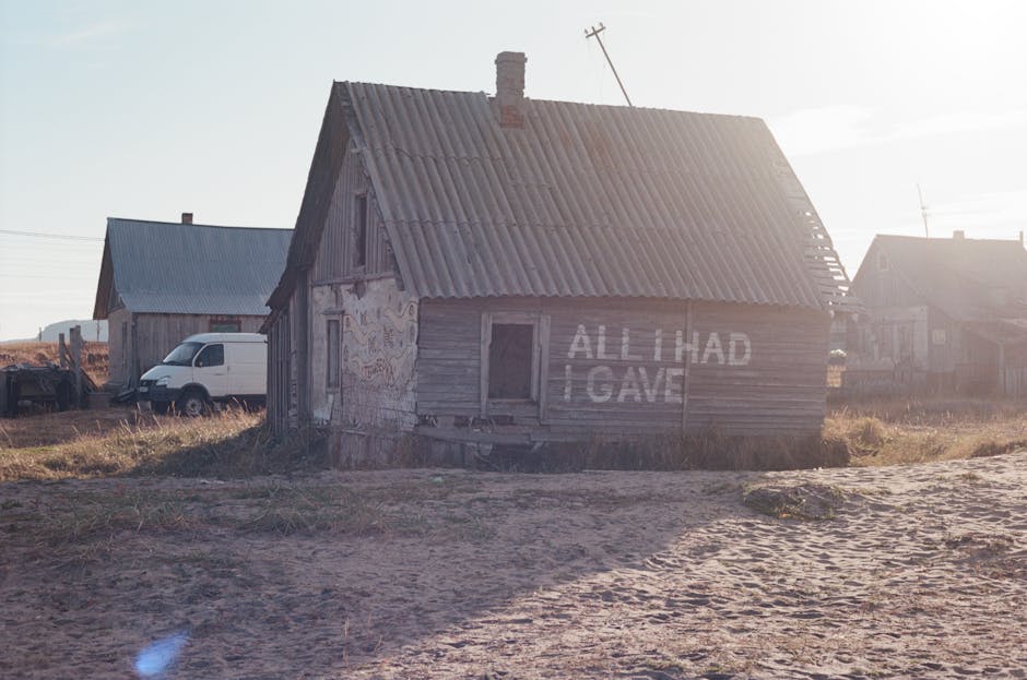 Derelict wooden house with message 'All I Had I Gave' in Teriberka, Russia.